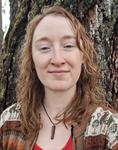 woman with long hair in front of a tree